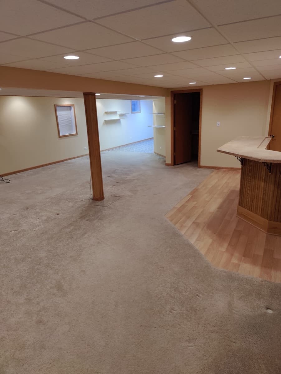 The same finished lower-level room cleared after the transition